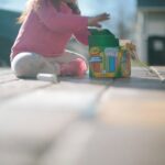 girl sitting beside box of chalk